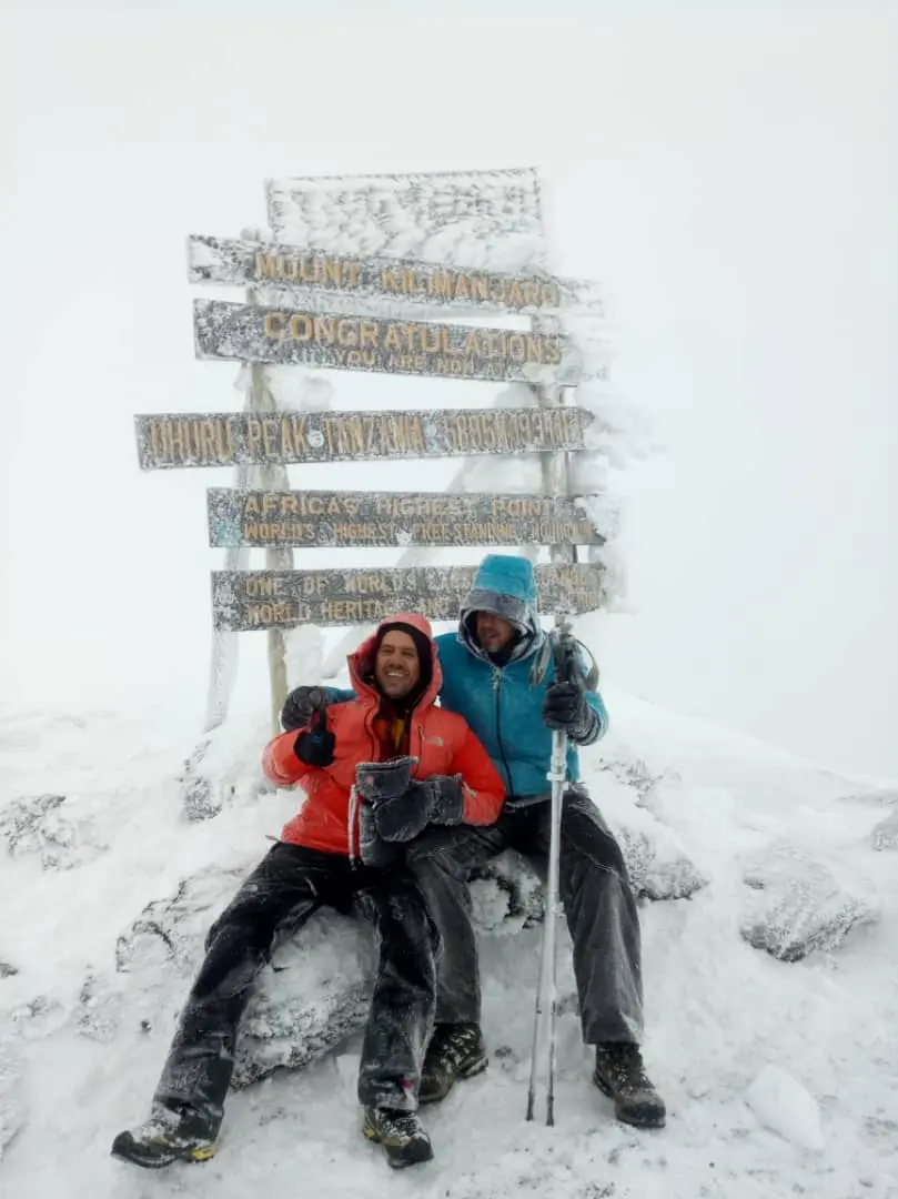 Climbers celebrating at Uhuru Peak on the summit of Mount Kilimanjaro